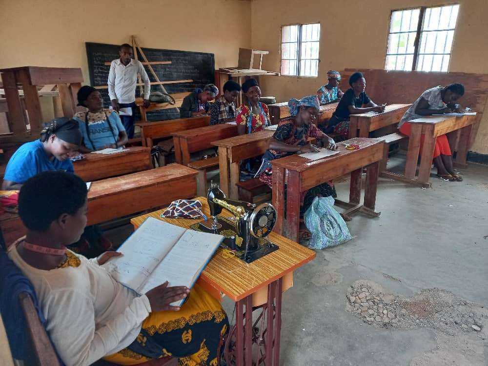 The photo shows Trainer of tailoring during practical part of the tailoring training.