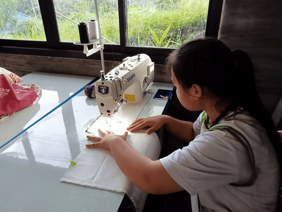 The children are practicing sewing bags.