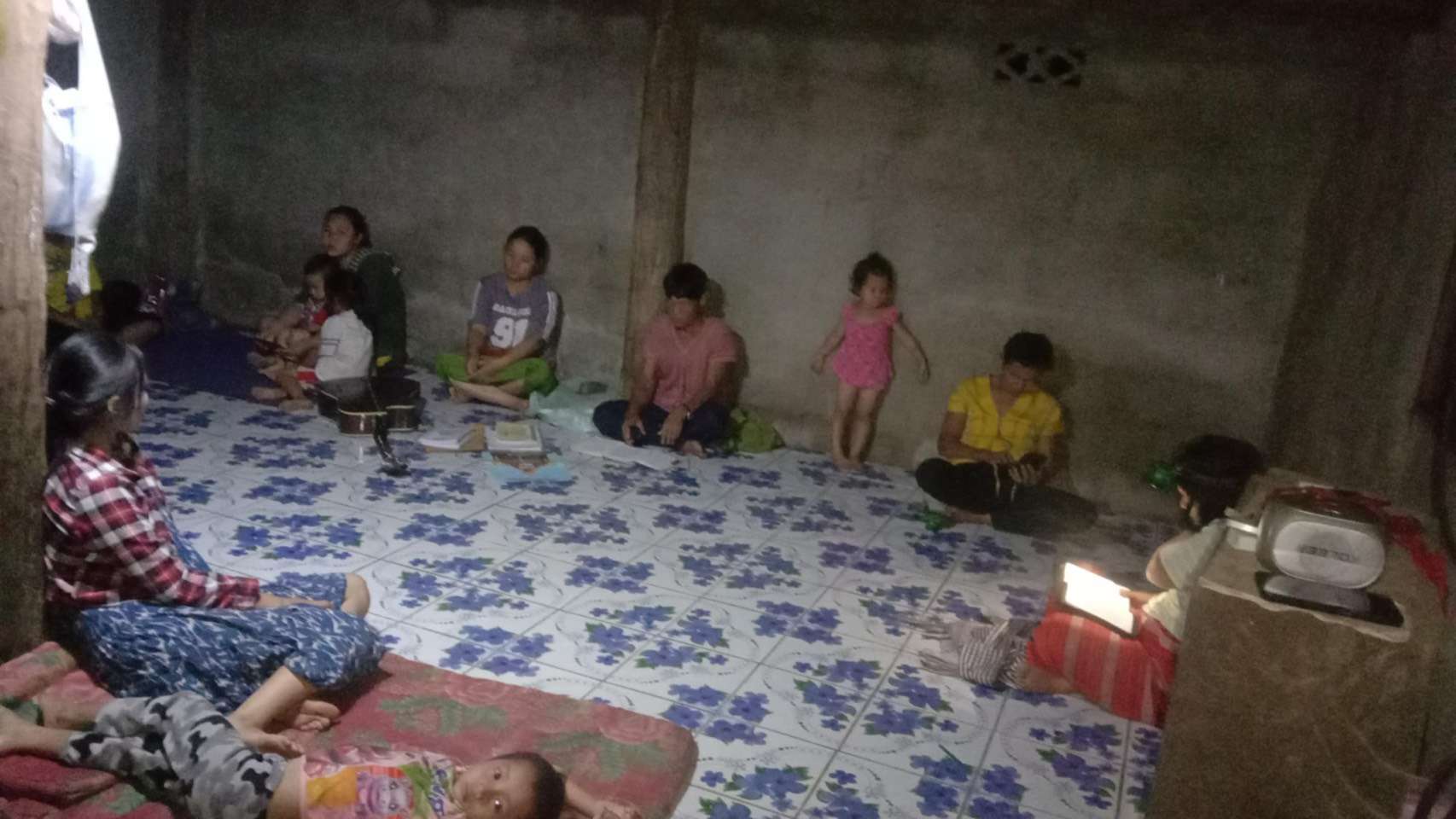 Children engaging in Bible study together, studying the scriptures by flashlight, showcasing their dedication and enthusiasm for learning