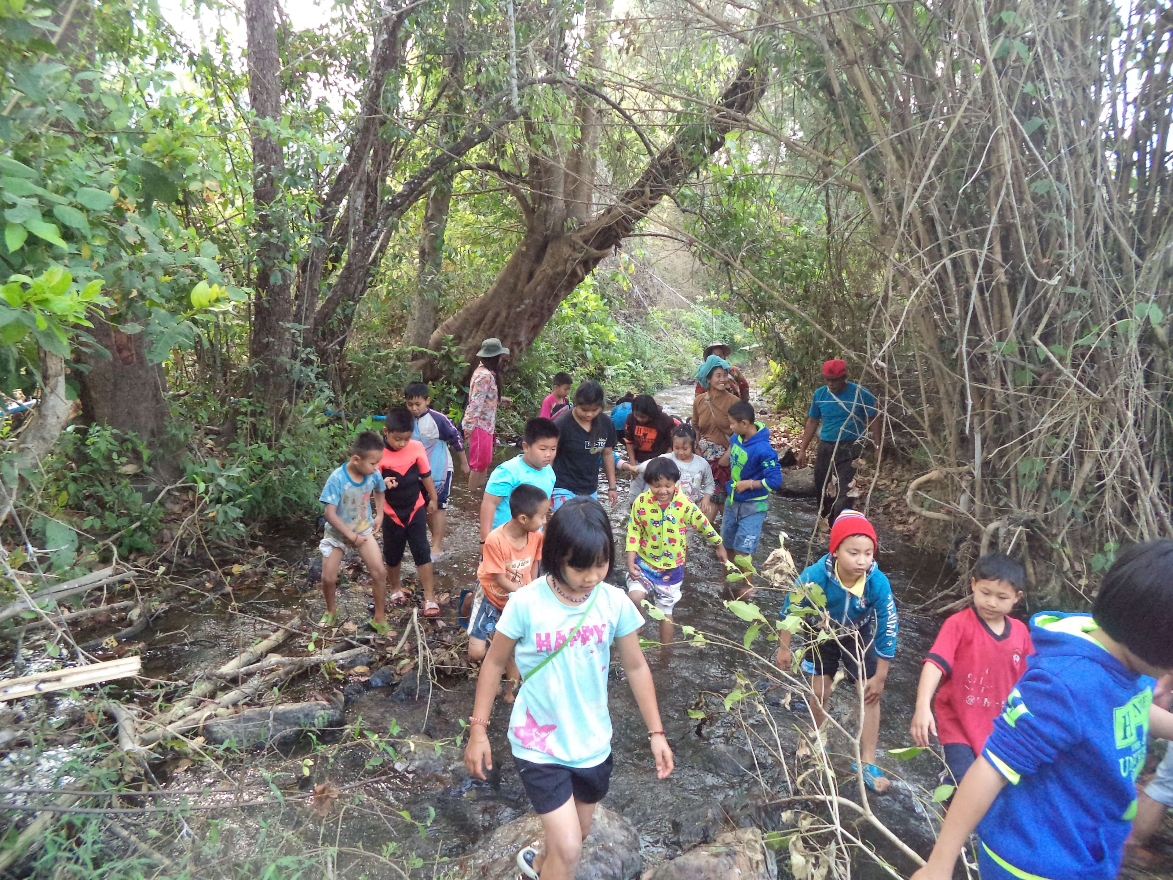 Children collect garbage along the river in the community.