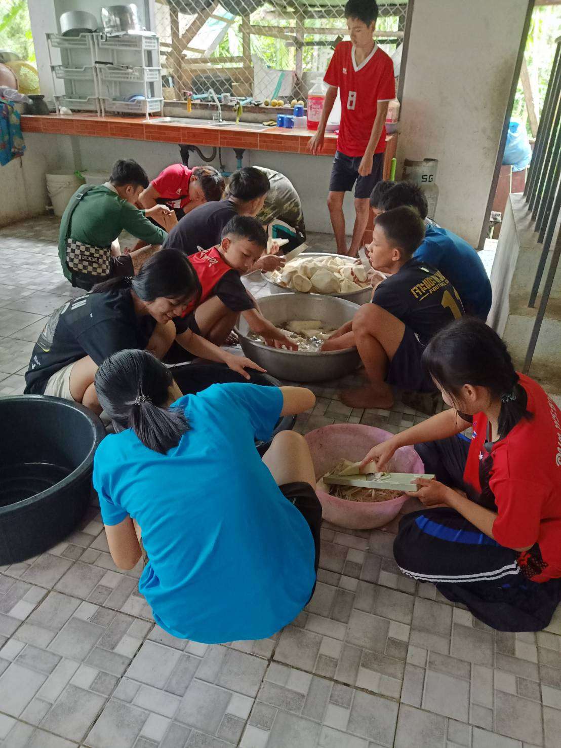 Children are chopping bamboo shoots to prepare for packaging.