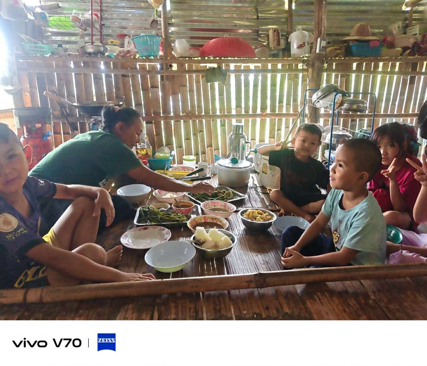 The teacher is serving rice and side dishes to the children.
