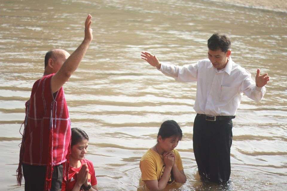 Children and parents actively participating in baptism, symbolizing their faith and commitment.

