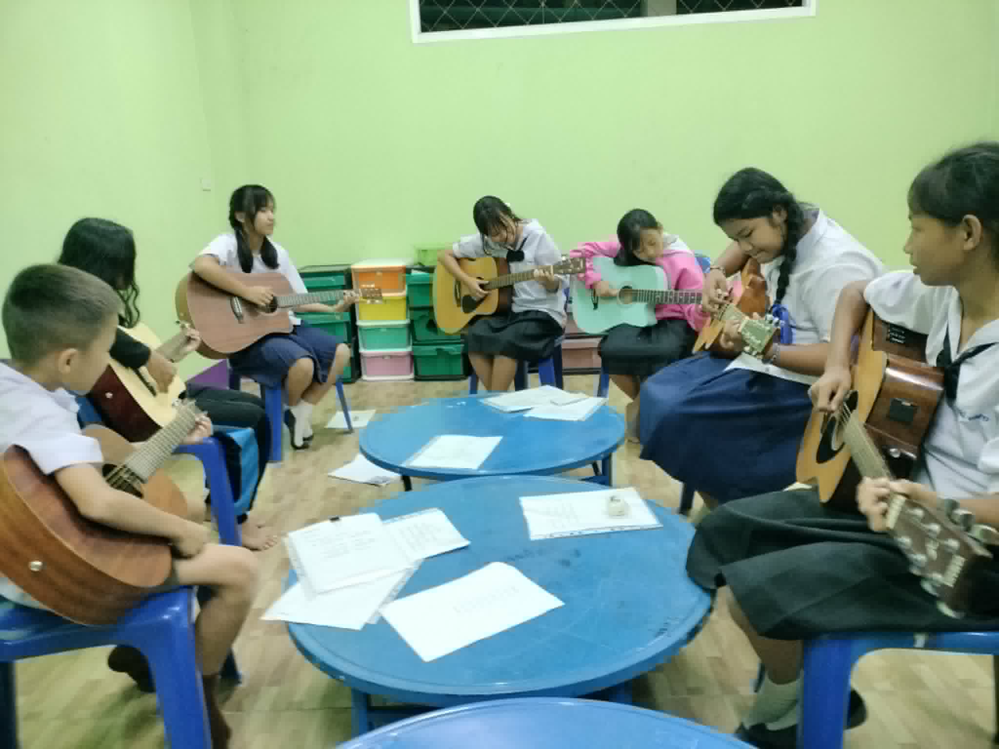 Young people come to learn the basics of guitar after school.